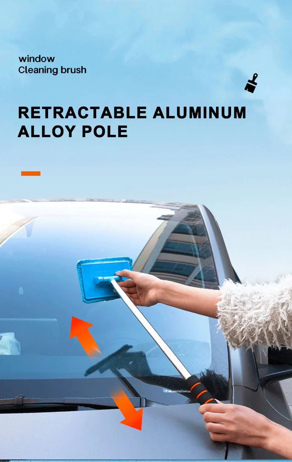 A hand is using a retractable aluminum alloy pole and cleaning brush to wipe the windshield of a car.
