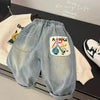 Light blue denim casual pants with an embroidered graphic featuring a smiling apple and people