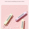 Three colors of a 2-in-1 needle threader and seam ripper set displayed on a pink background.