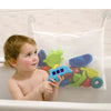A toddler is holding a blue suction cup toy storage bag filled with colorful plastic toys in a bathroom setting.