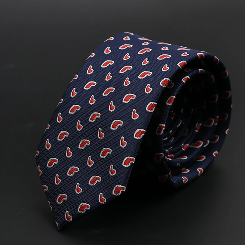 Corbata azul oscuro con patrón repetido de formas estilizadas rojas y blancas.