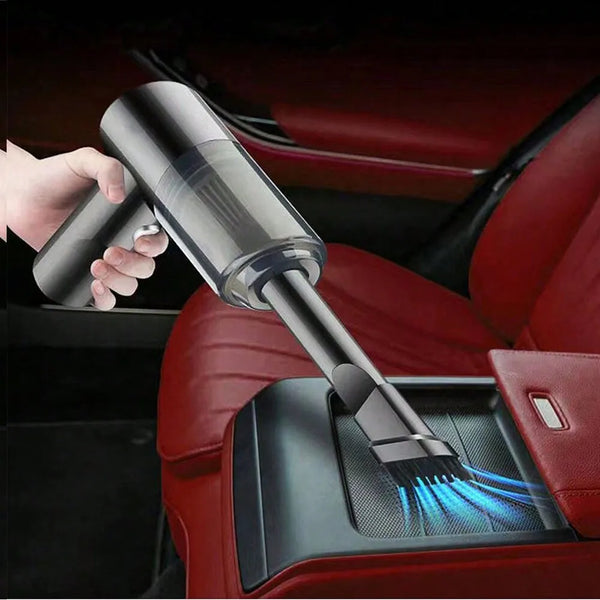 A hand is using a portable 3-in-1 USB vacuum cleaner with a blower function on a car seat.