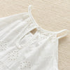 White cotton suspenders dress for a toddler girl with delicate eyelet embroidery