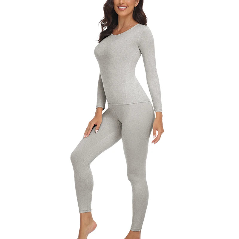 A woman models a long-sleeved thermal top and leggings set in gray.
