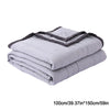 A stack of light gray breathable cooling throw blankets folded and rolled.