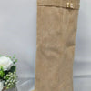 A full-length view of a beige knee-high boot with a chunky heel and a metal buckle detail.