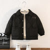 A black quilted winter jacket for boys with a soft fleece lining hanging on a white hanger.