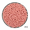 A circular arrangement of pink water beads filling a black plate.