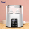 A white multi-function baby bottle warmer and sterilizer appliance sitting on a wooden surface.