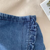 A close-up of a denim skirt and top set featuring lace trim on the neckline.