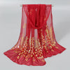 A sheer red chiffon scarf with gold shimmer embroidery displayed on a hanger.