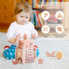 A young child plays with a pink wooden castle stacking puzzle toy featuring beads and various shapes.