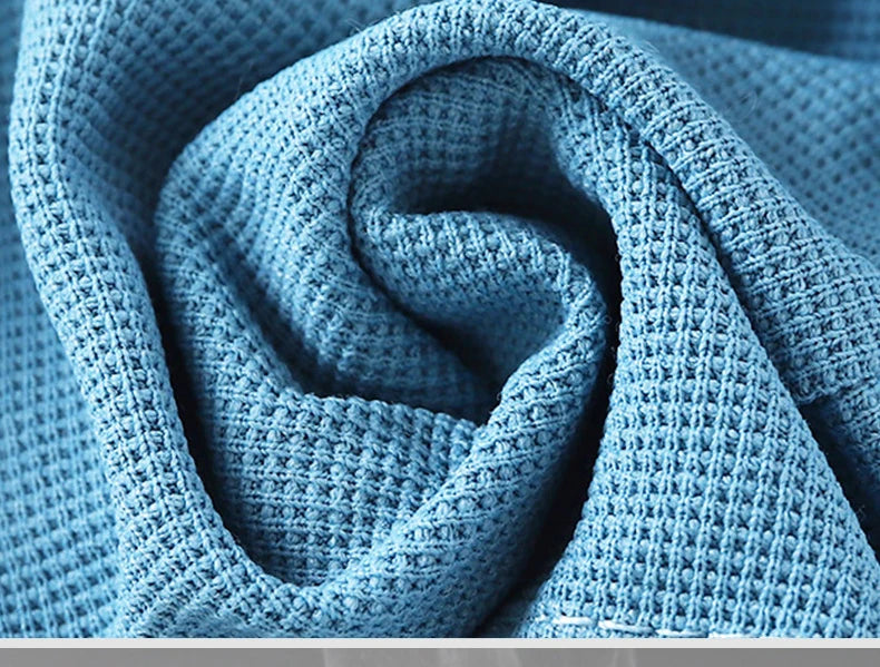 A close-up of light blue knitted beach shorts rolled into a spiral.