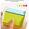 A hand rotates a wooden spinning drum showing five different colors for color cognition training.