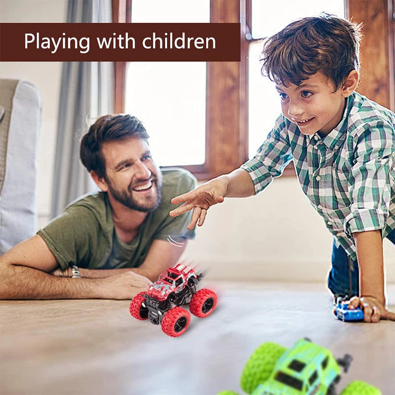 A boy is playing with a red pull-back stunt SUV toy car on a wooden table.