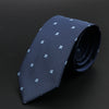 Corbata estampada azul oscuro doblada sobre fondo negro.