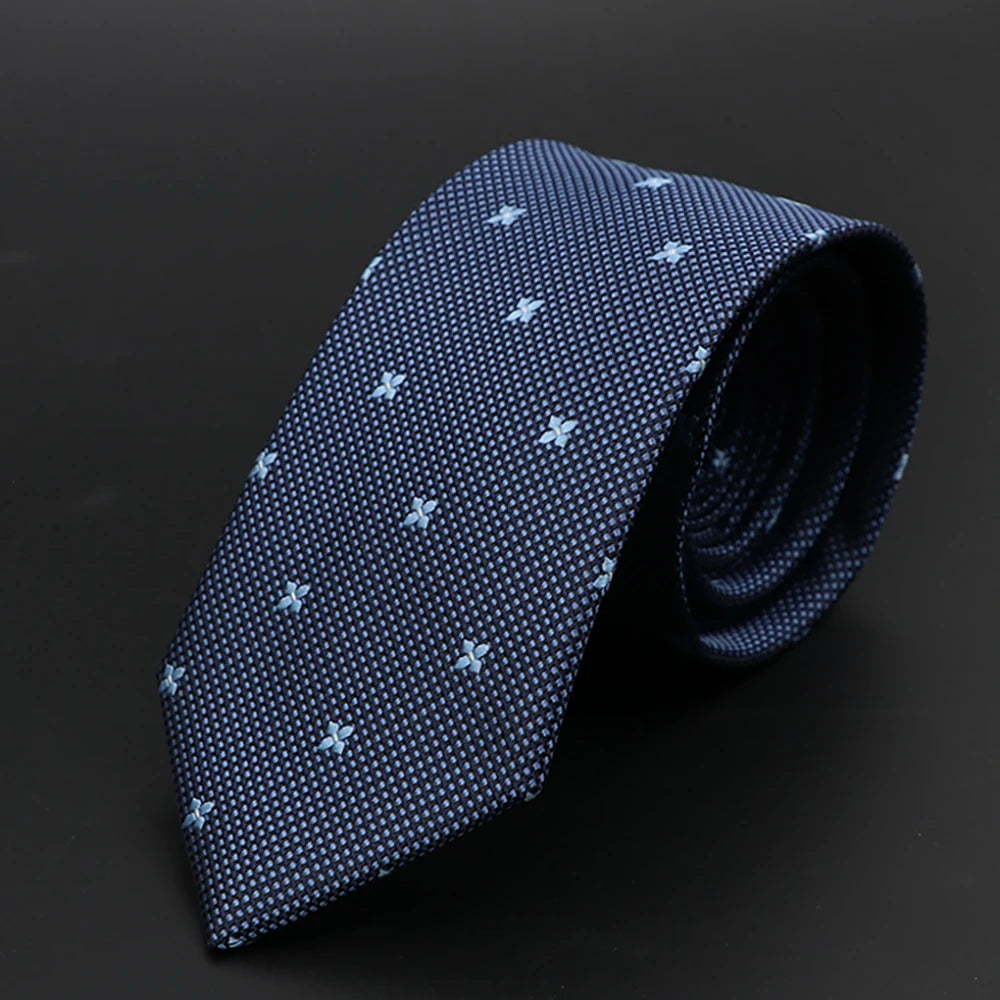 Corbata estampada azul oscuro doblada sobre fondo negro.