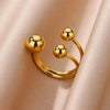 Nahaufnahme eines mehrlagigen geometrischen Rings in Goldton mit offenem Design und runden Perlen.
