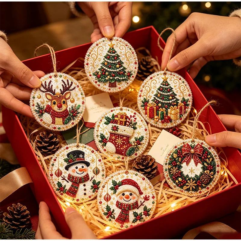 Hands place festive diamond painting wooden ornaments in a red box surrounded by pine cones and straw.