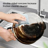 Hands are using a double-sided concave friction cleaner to clean a pot on a kitchen sink.