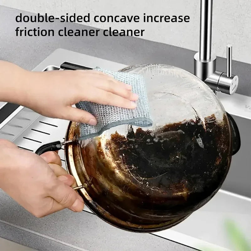 Hands are using a double-sided concave friction cleaner to clean a pot on a kitchen sink.