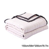 A stack of white breathable cooling throw blankets folded and rolled.