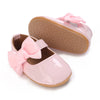 Pink soft non-slip baby first walker shoes with a bow on the toe and a textured sole.