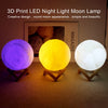 Three 3D printed LED moon lamps glowing purple, yellow, and white on a dark surface.