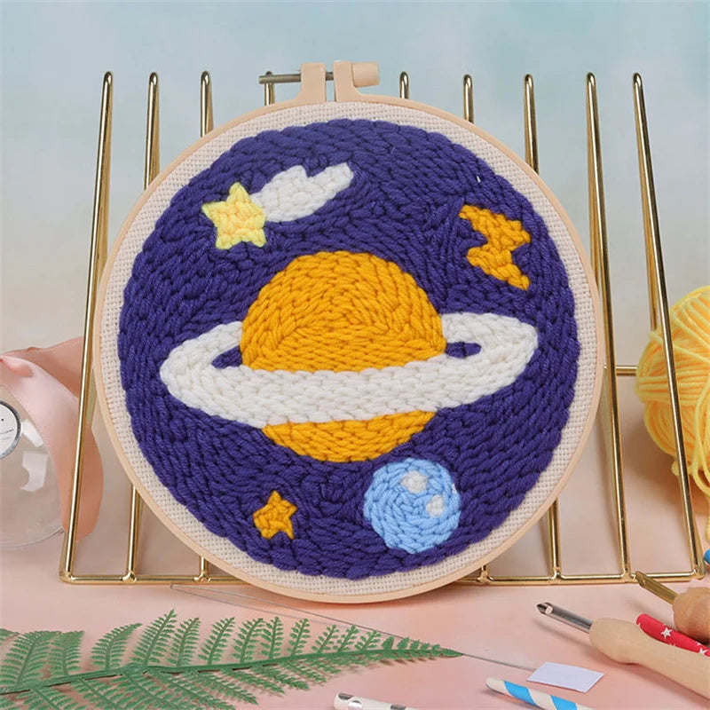 Kit de bordado punch needle morado y amarillo con diseño celestial en lienzo circular.