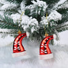 A set of two red and white candy cane Christmas tree ornaments decorated with flocking, resting on a white fluffy surface.