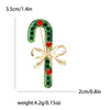 Broche de campana esmaltada con pedrería dorada y piedras verdes y rojas