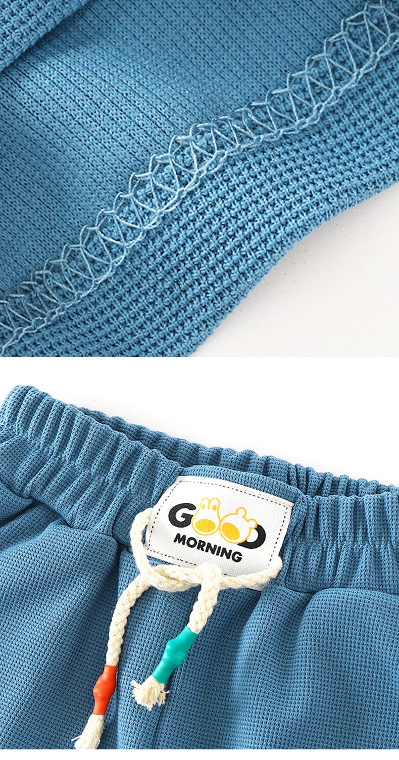 Close-up of blue kids beach shorts with an elastic waist featuring a woven trim and a tag.