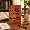 Un guide d'étude biblique relié en cuir posé sur une table en bois à côté d'un carnet et de lunettes.
