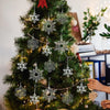 Et dekorert juletre pyntet med sølv- og grønne akrylsnøfnugg.