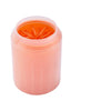 A pink portable dog paw cleaner cup with soft silicone combs inside.