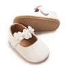White soft non-slip baby first walker shoes with a leather sole and decorative white floral accents.