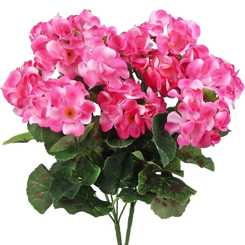 A bouquet of pink geranium flowers with green leaves.