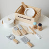 A wooden kitchen tool set including a cutting board, knife, fork, and spatula is displayed in a wooden box.