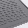 A gray silicone stove protector mat with raised ridges for use on induction and glass-top cooktops.