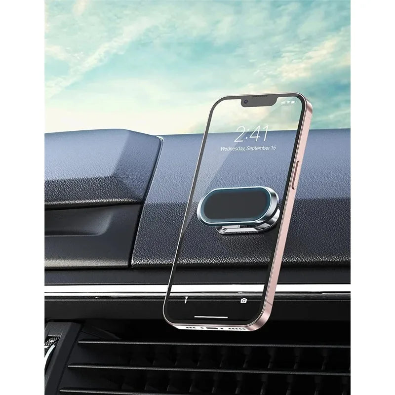 A pink smartphone is mounted on a black car dashboard using a magnetic rotating phone mount.