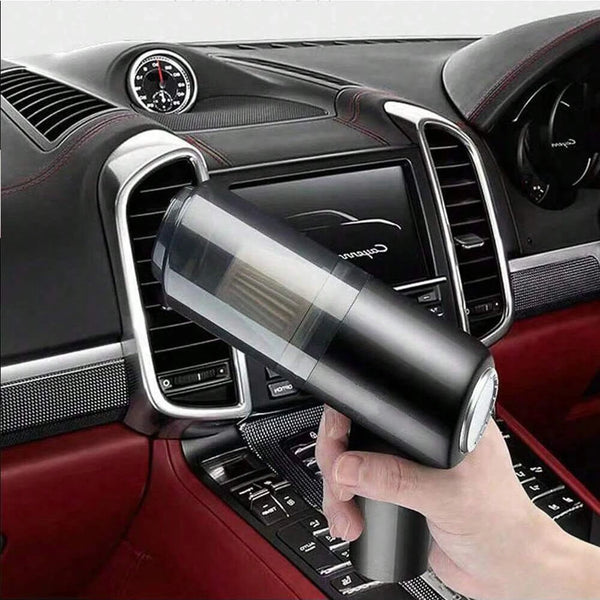 A hand holds a portable 3-in-1 USB vacuum cleaner with a blower function in a car interior.