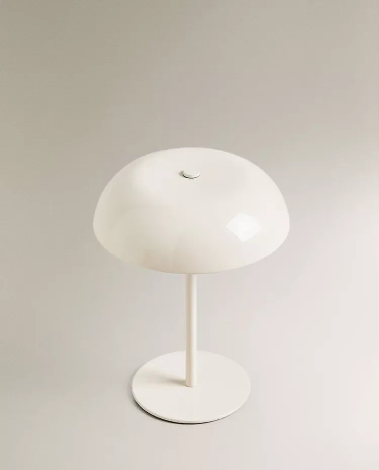 A white portable touch table lamp with a dome-shaped shade and a slender stand.