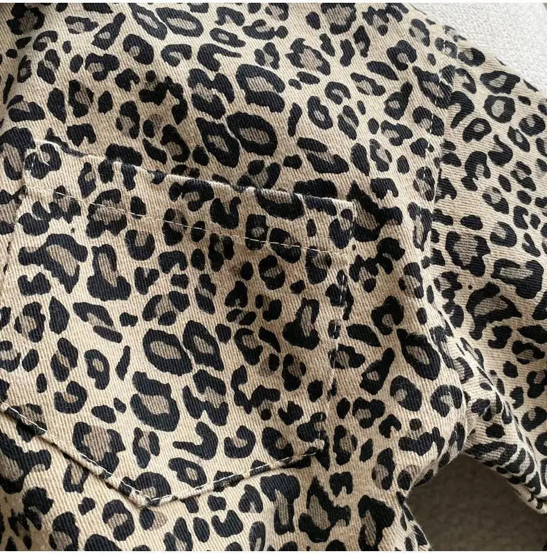Close-up of a boys' leopard print denim jacket showing the fabric texture and stitching.