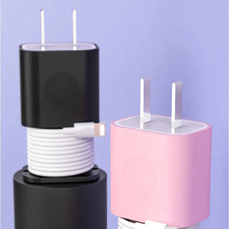 A black silicone charger protector and cable organizer with white cables and pink housing.