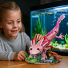 A young girl is interacting with a pink dinosaur sculpture building block set in an aquarium display.