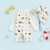 A cream long sleeve rash guard swimsuit with a whale print featuring various animal silhouettes and a matching sun hat for a 