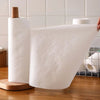 Un rouleau de chiffons de nettoyage blancs réutilisables non tissés avec un applicateur en bois visible sur une surface en bo