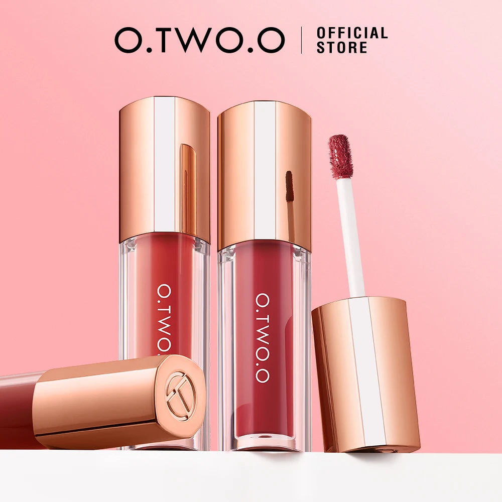 Three tubes of O.TWO.O lip tint in shades of red and pink with a brush shown next to them.
