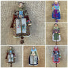 A collection of handcrafted kitchen witch dolls featuring antique charm and detailed clothing.