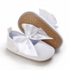White soft non-slip baby first walker shoes with a satin bow detail